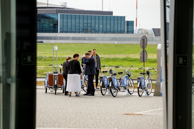 UCzestnicy konferencji przy stacji z rowerami.