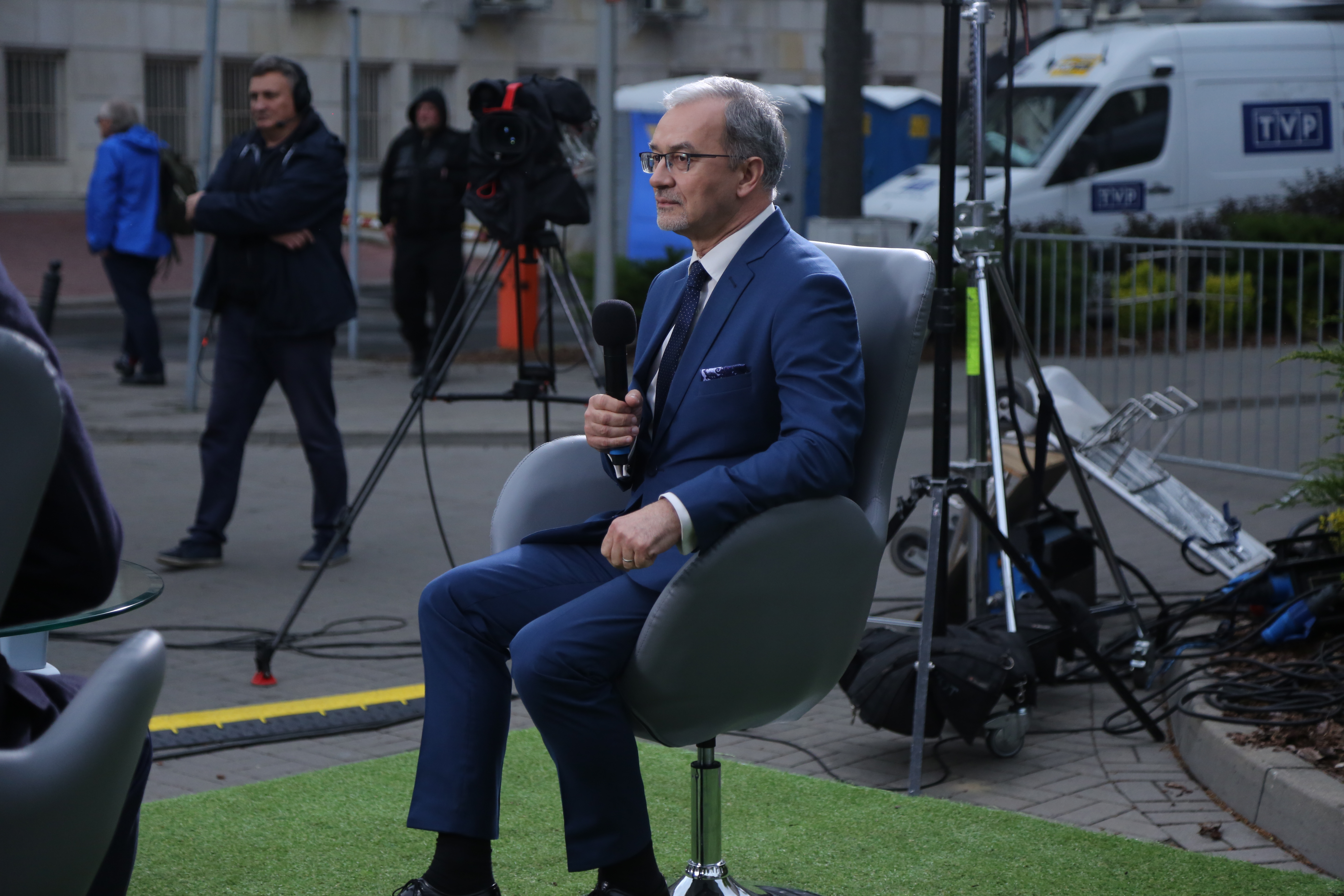 Minister Kwieciński siedzi na fotelu w dłoni trzyma mikrofon