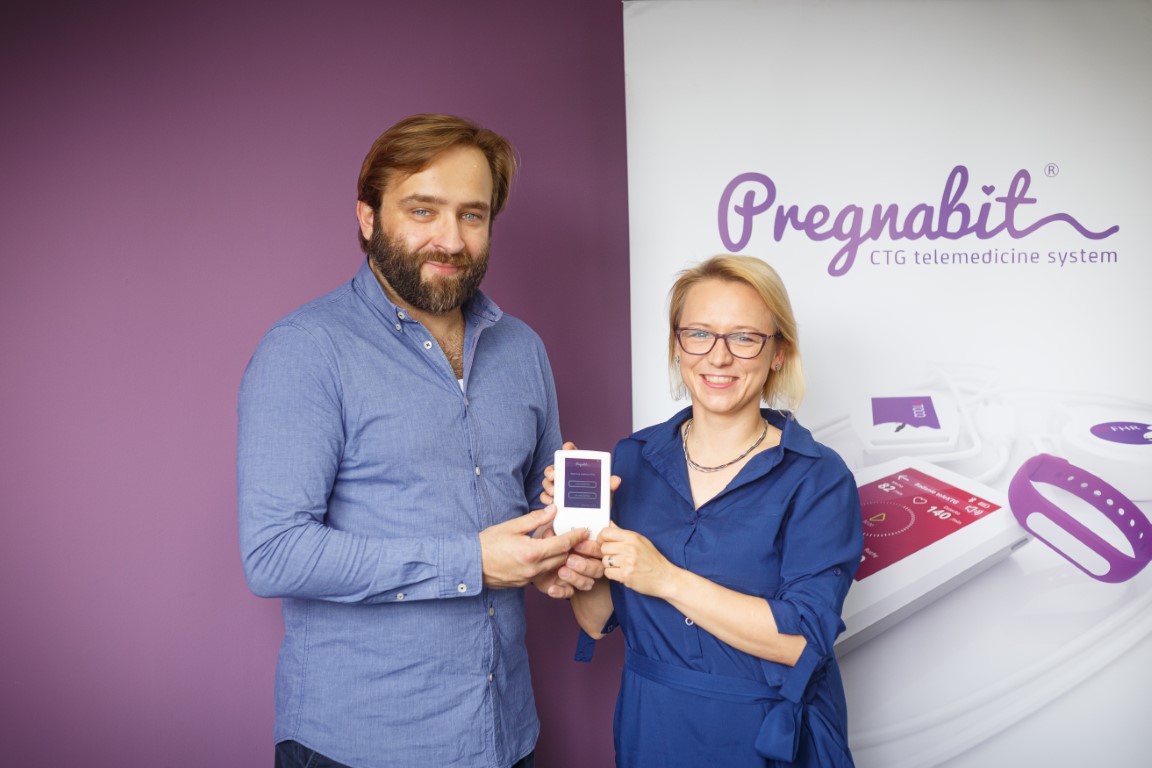 Man and women with a small mobile CTG apparatus (Pregnabit) in hands.