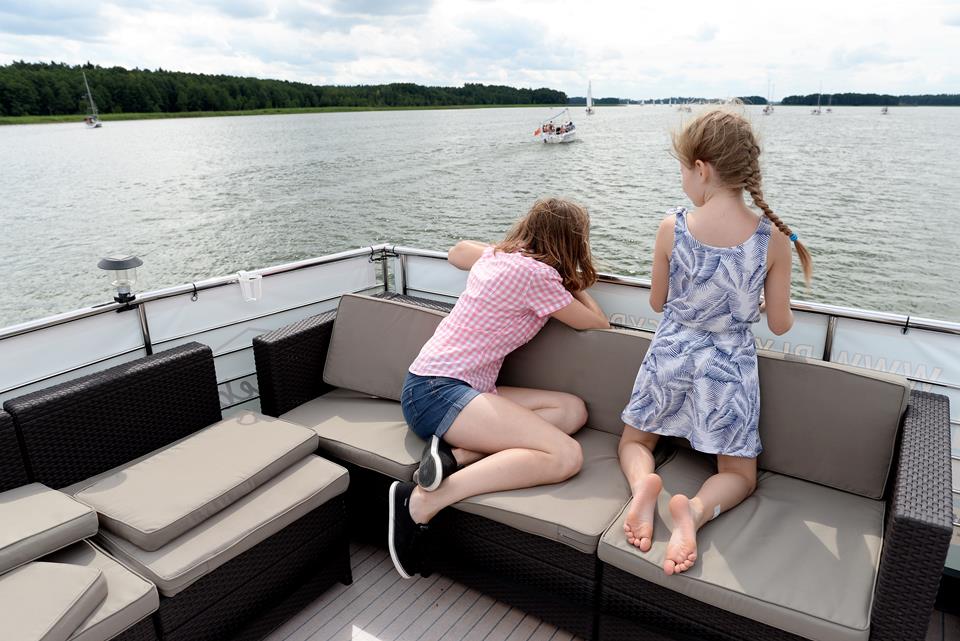 Two girls sitting backwards on a houseboat
