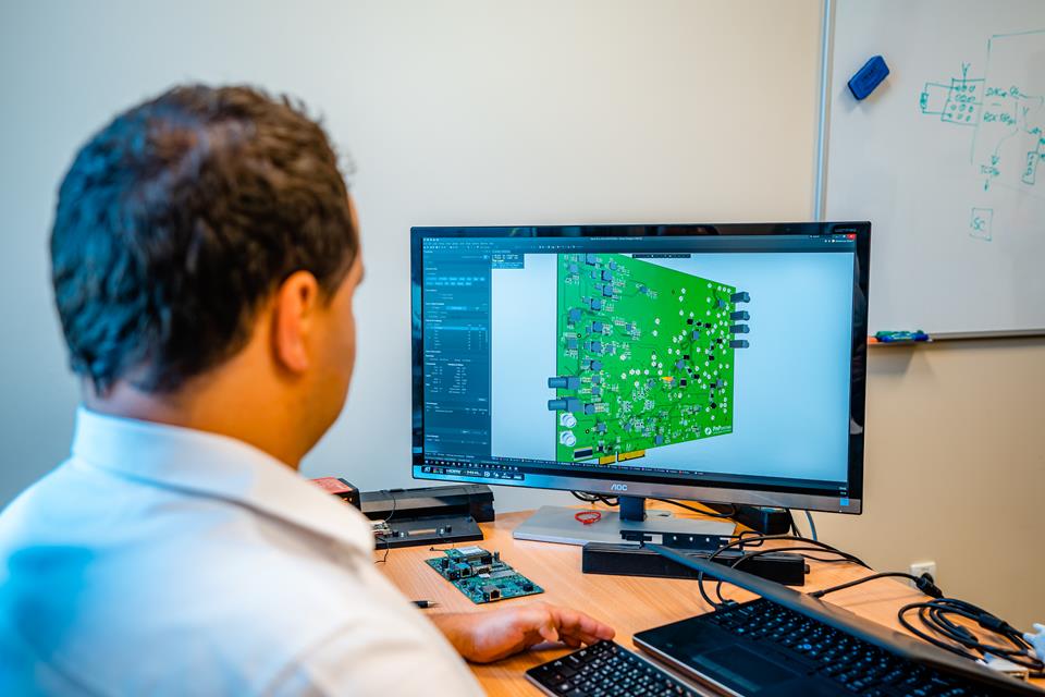 Man working at a monitor with the PnP system displayed.