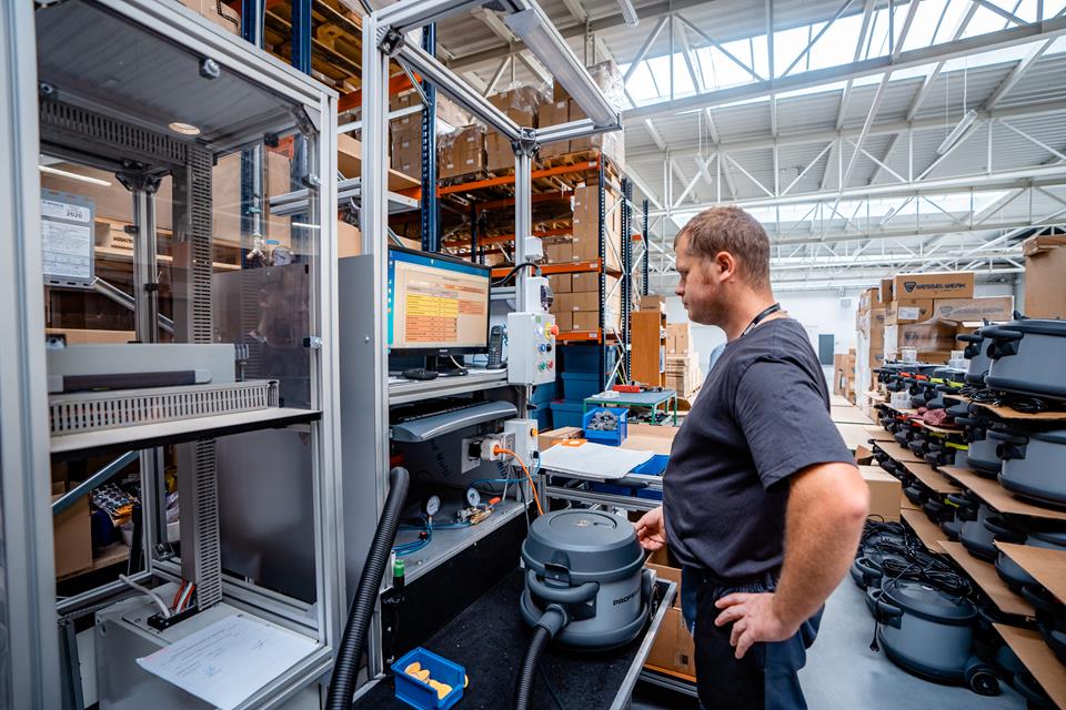 man at a machine in a vacuum cleaner factory