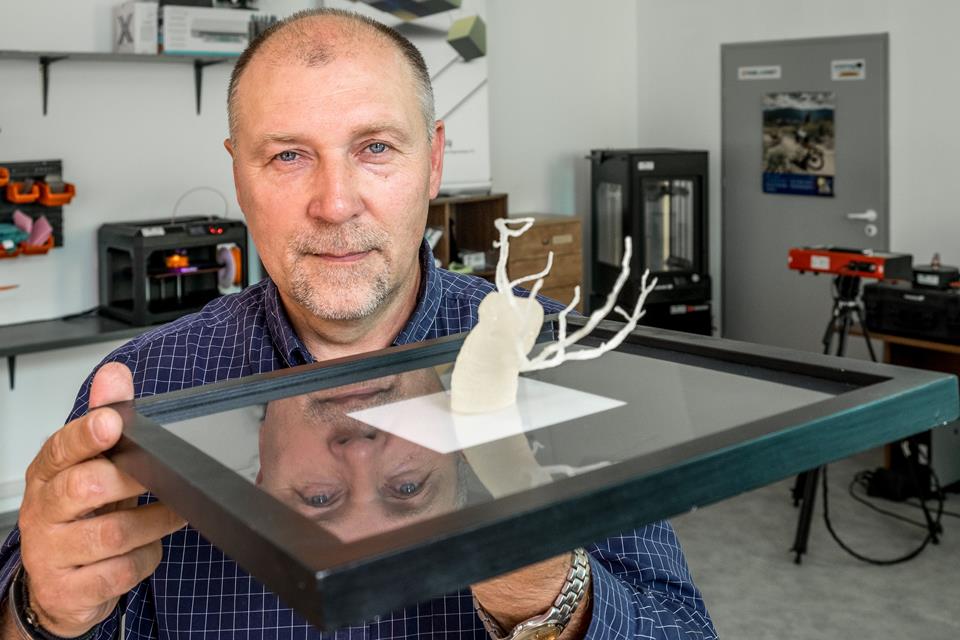 Mężczyzna pokazuje produkt wydrukowany w 3D