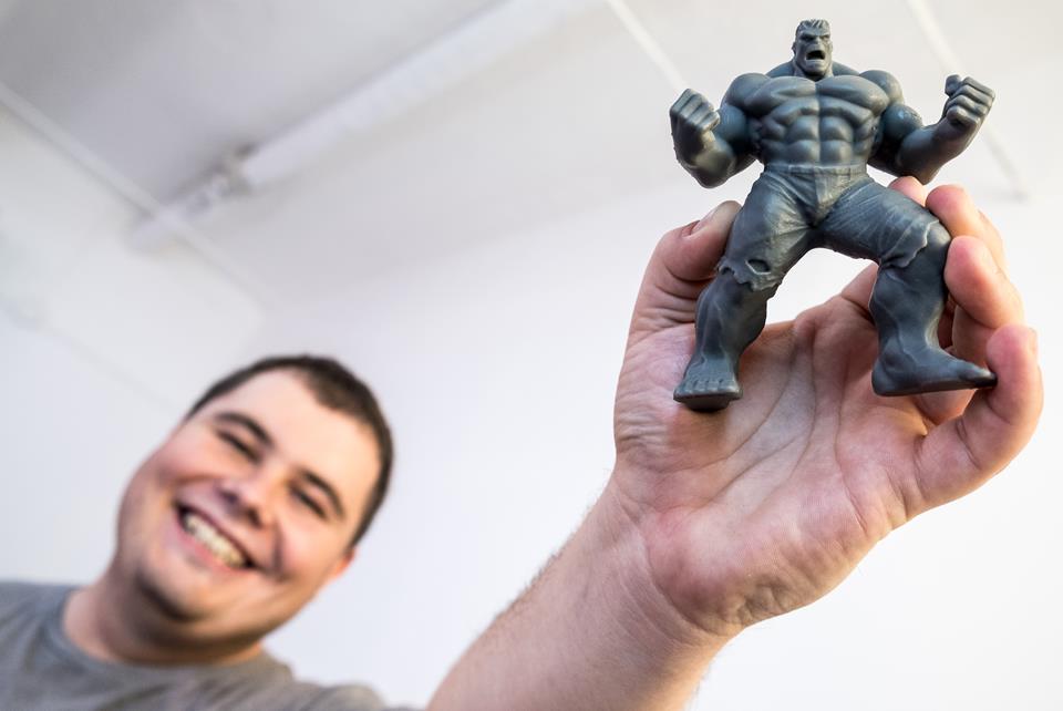 Man shows a 3D printed figurine 